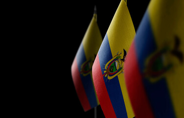 Small national flags of the Ecuador on a black background