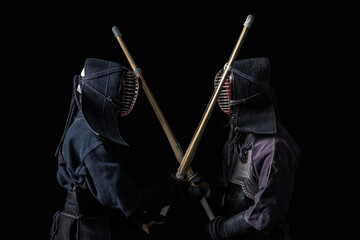 Japanese kendo fighters with bamboo swords on a black background