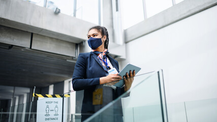 Young air hostess in airport lounge, coronavirus, travel and new normal.