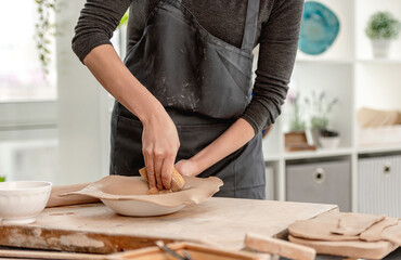Woman using wet sponge for plate forming