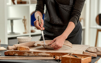 Woman using knife for plate forming