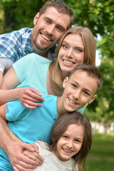 Fototapeta premium Portrait of happy young family in summer park