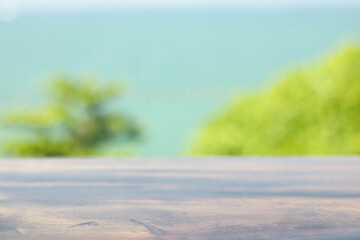 The blur cool sea background with wood floor foreground on horizon tropical sandy beach; relaxing outdoors vacation with heavenly mind view at a resort deck touching sunshine, sky surf summer clouds.