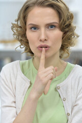 Fototapeta premium Beautiful woman gesturing silence posing against white