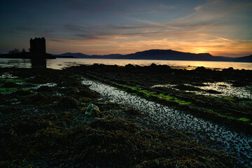 Castle stalker with calm sea water at sunset. located in the Highlands of Scotland.