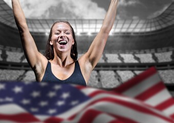 American flag waving over caucasian female athlete celebrating against sports stadium