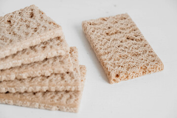 Stacked rye crisp bread on a white wooden background. Copy, empty space for text