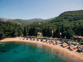 Fototapeta na wymiar View of the royal beach of Przno in Montenegro against the backdrop of green slopes