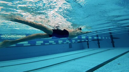 Male athlete swimming underwater in a close up