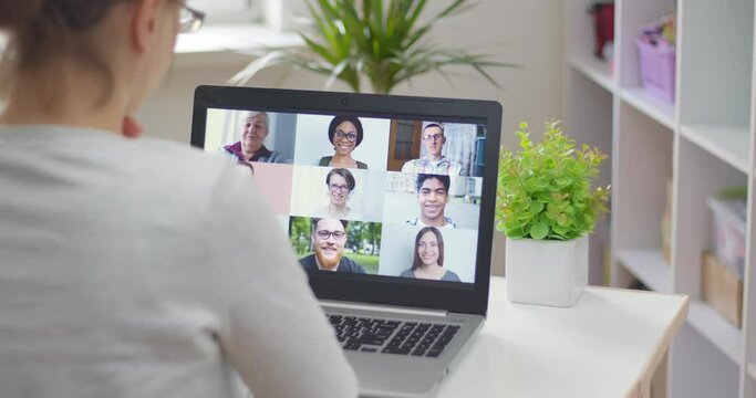 A woman speaks remotely with people using a laptop, teaches an online training course at home. Video conference of friends. Webinar. 4K.