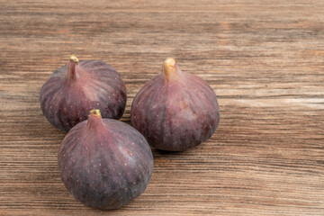 three ripe fig fruit on a wooden table