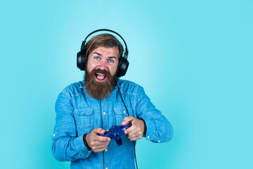 caucasian hipster with beard and stylish hair in headset with gaming console, modern life