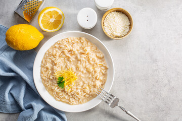Risotto with lemon and parmesan in light grey background. Top view. Copy space.