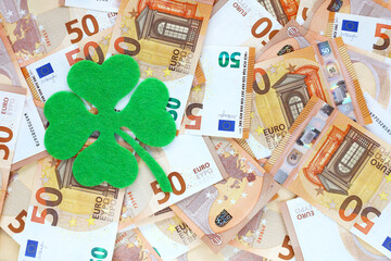 Green felt four leaf clover on 50 fifty euro banknotes background. Euro currency in Europe....