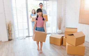 Happy Asian family holding cardboard box run into new home. Relocation concept