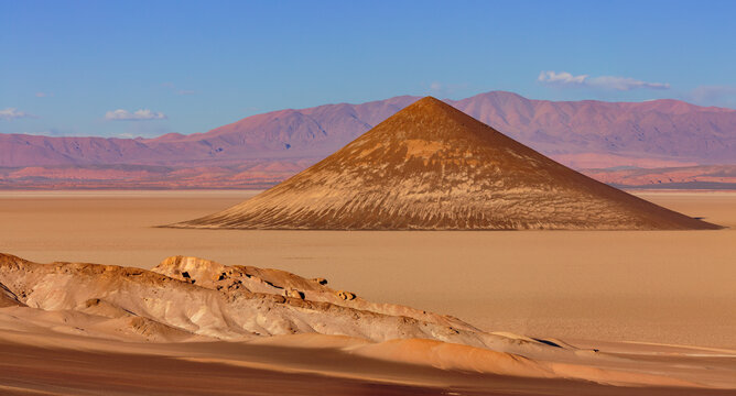 Sunset over the surreal volcanic cone Cono de Arita on the salt flat Salar de Arizaro in northwest Argentina