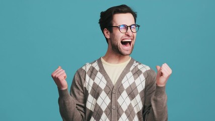 A happy man rejoicing a victory while jumping on the spot in the studio