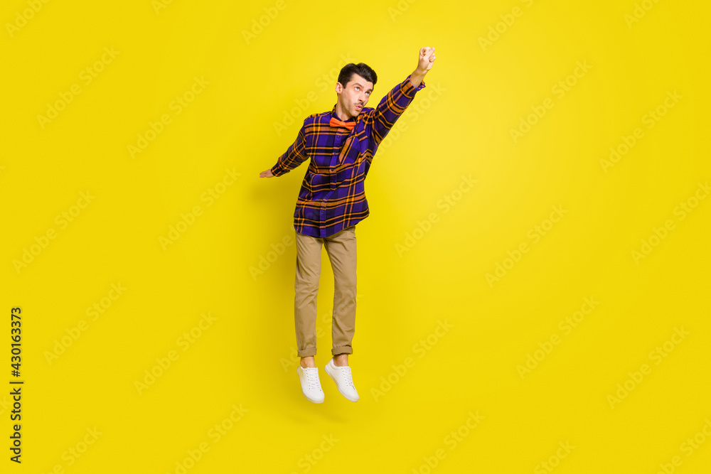 Sticker full length photo of young handsome man jump up air fly superhero isolated over yellow color backgro