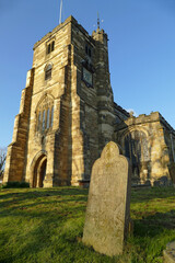 Gravestone in front of the beautiful St Dunstan's Church on a sunny day in Cranbrook, England, Europe
