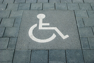 Disabled parking sign painted on parking lot road stone surface