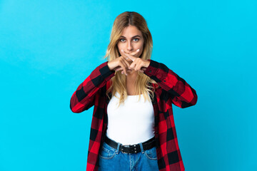 Young blonde Uruguayan woman over isolated background showing a sign of silence gesture