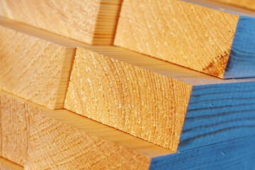 Obraz premium The wooden bars are stacked in a stack. Sawing drying and marketing of wood. Industrial background.