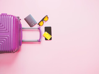 Obraz premium summer travel concept from credit card and suitcase with summer collection on pink background.