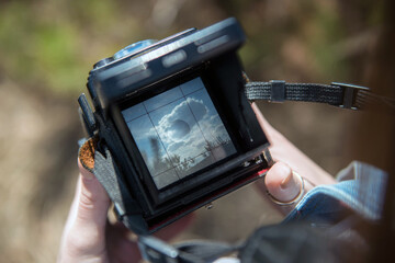 An overhead view of hands holding a medium format retro film camera. Close-up
