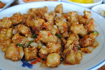 Close up of fried chicken bites with red hot peppers