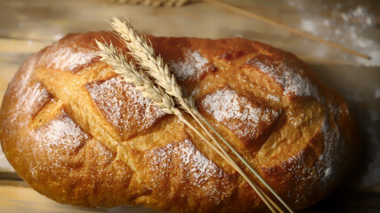Selective focus. Fresh wheat bread. Flour and ears. Warm toning.