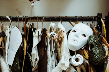 white mask and theatrical costume on  coat stand - obrazy, fototapety, plakaty