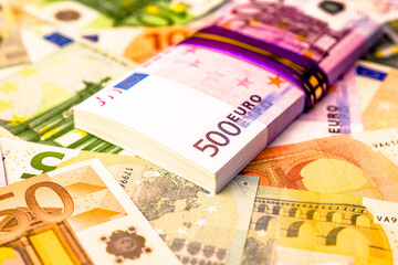 A pack of European currency lies on the background of the Euro
