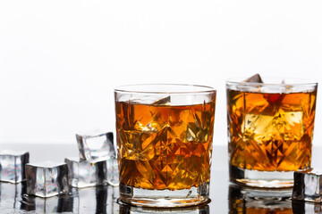 Golden whiskey in glass with ice cubes