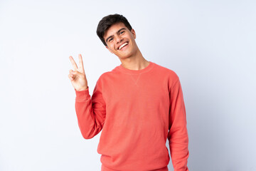 Fototapeta premium Handsome man over isolated blue background smiling and showing victory sign