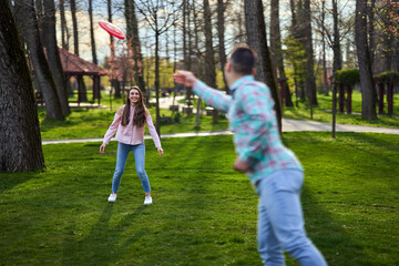 Obraz premium Young couple playing freesbie in the park