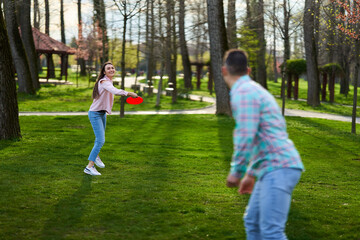 Young couple playing freesbie in the park