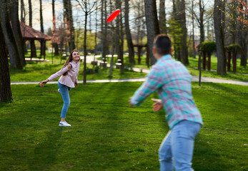 Young couple playing freesbie in the park