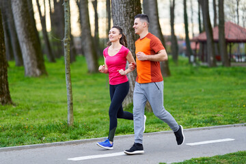 Obraz premium Young couple running in the park