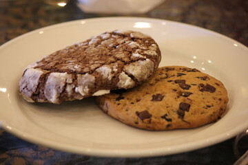 Two chocolate chip cookies in a white plate