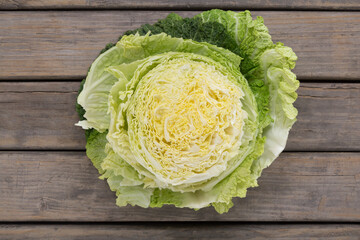 close-up of cabbage cut in half, overhead shot with rustic wood base