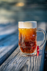 mug with foamy drink on wooden surface, blurred image