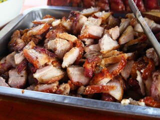 Metal tray filled with slices of roasted pork meat