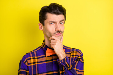 Obraz premium Photo of young man unhappy uncertain hand touch chin think thoughtful isolated over yellow color background