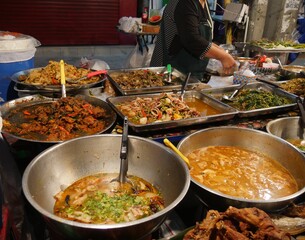 Assortment of freshly cooked street food displayed at a food market in Thailand.