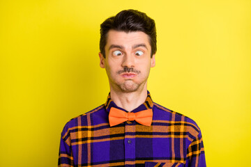 Photo of young man fooling grimacing hold breath humor joke dumb silly isolated over yellow color background