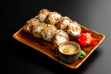 Sushi and rolls, Japanese sea cuisine. Served plates for the restaurant menu on a black background.