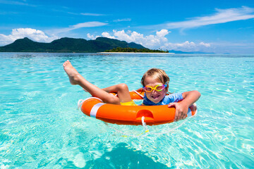 Child on tropical beach. Sea vacation with kids.