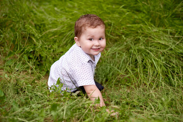 little boy playing in green grass. world children's day content