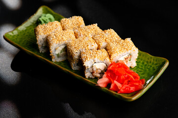 Sushi and rolls, Japanese sea cuisine. Served plates for the restaurant menu on a black background.