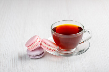 macaroons and a cup of tea on a light wooden table. Morning tea and sweets.